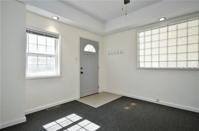 foyer entrance with visible vents, baseboards, and a textured wall