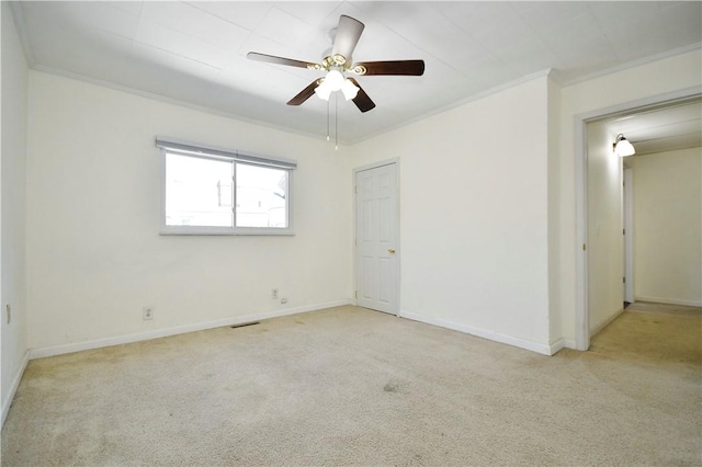 unfurnished room with baseboards, carpet, visible vents, and ornamental molding