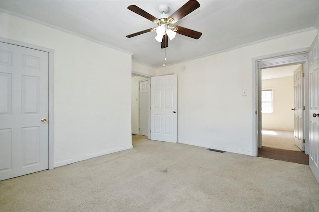 unfurnished bedroom featuring visible vents, crown molding, ceiling fan, baseboards, and carpet floors