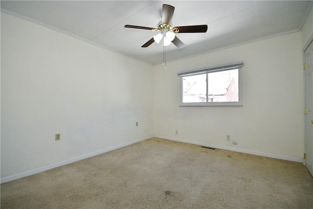 carpeted spare room featuring visible vents, baseboards, ceiling fan, and crown molding