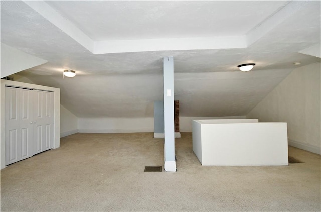 additional living space with baseboards, lofted ceiling, and carpet floors