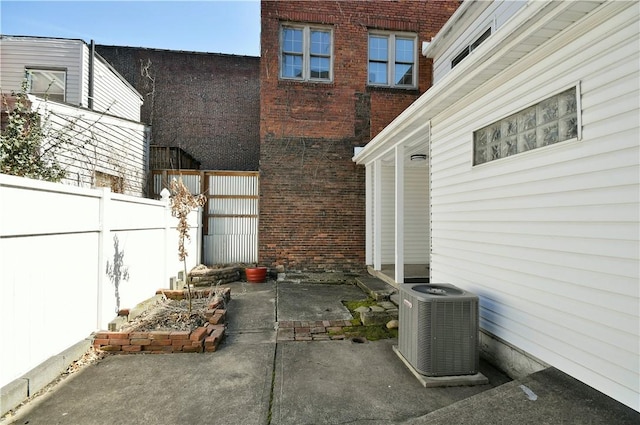 view of patio / terrace with central air condition unit and fence