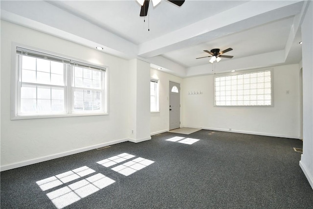 interior space with a tray ceiling, a ceiling fan, and baseboards