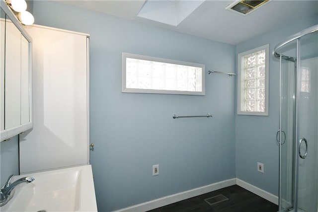 full bathroom featuring visible vents, a stall shower, baseboards, and a sink