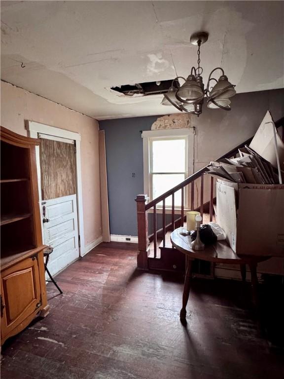 living area featuring a notable chandelier and baseboards