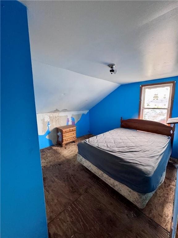 bedroom with lofted ceiling and wood finished floors