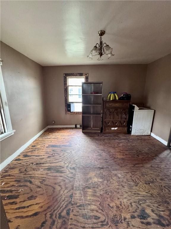 interior space with a notable chandelier and baseboards