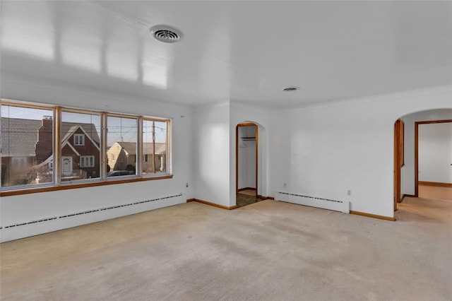 carpeted empty room with arched walkways, visible vents, and a baseboard radiator