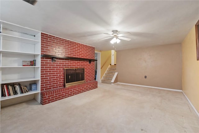 unfurnished living room with stairway, baseboards, ceiling fan, a brick fireplace, and carpet flooring