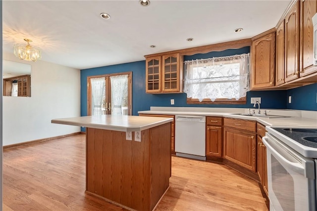 kitchen featuring plenty of natural light, white appliances, a kitchen island, and light wood-style floors