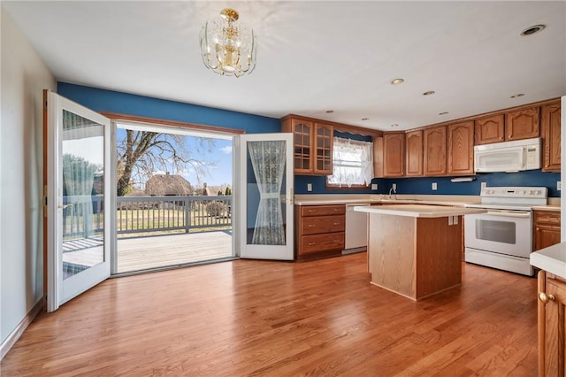 kitchen featuring a sink, white appliances, brown cabinetry, and light countertops