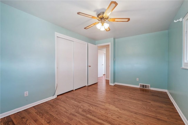 unfurnished bedroom with visible vents, baseboards, and wood finished floors