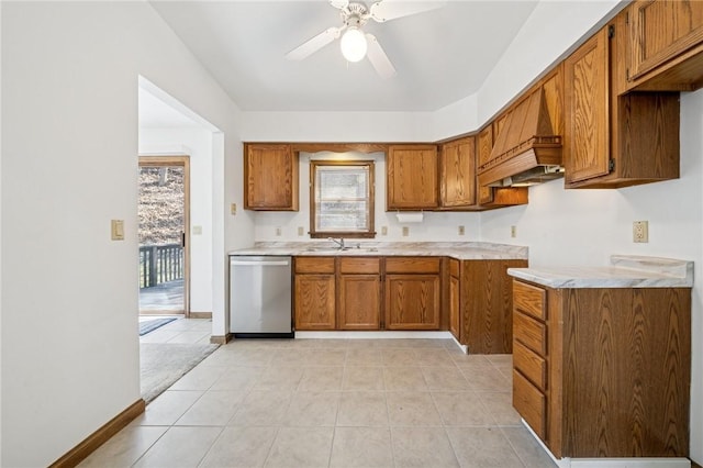 kitchen featuring a sink, brown cabinets, light countertops, and stainless steel dishwasher