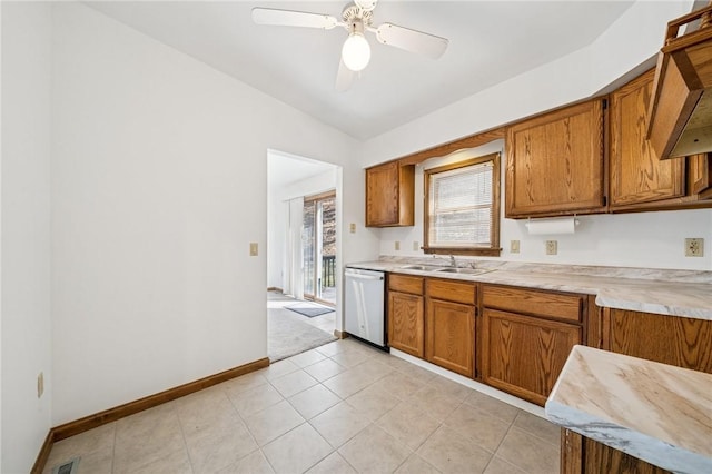 kitchen with a sink, brown cabinetry, light countertops, dishwasher, and ceiling fan