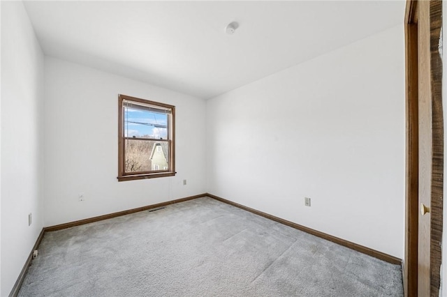 spare room with visible vents, baseboards, and light carpet