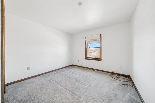 empty room with light colored carpet and baseboards