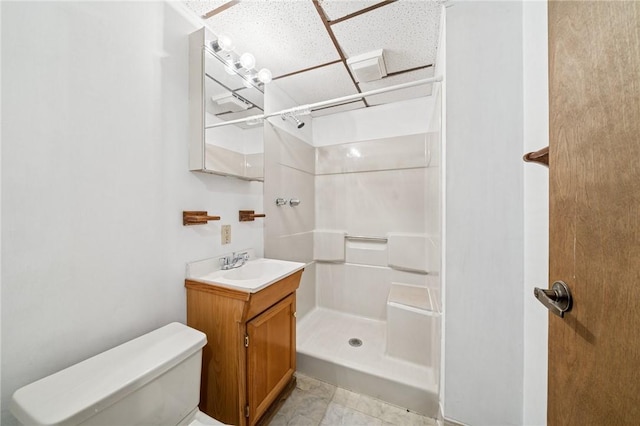 full bath featuring vanity, a shower stall, toilet, and a paneled ceiling