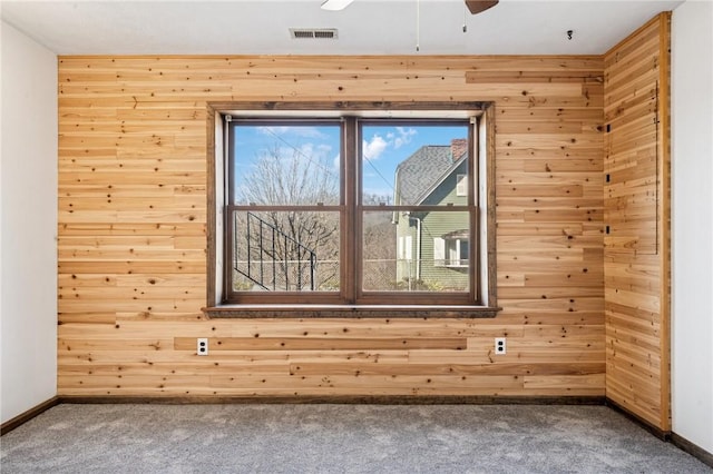 empty room with a ceiling fan, visible vents, carpet floors, and baseboards