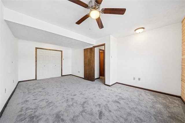 unfurnished bedroom with a closet, baseboards, carpet, and a ceiling fan