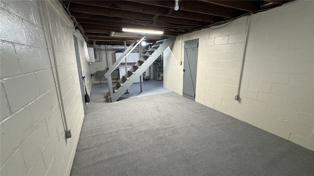 unfinished basement featuring carpet floors and stairs