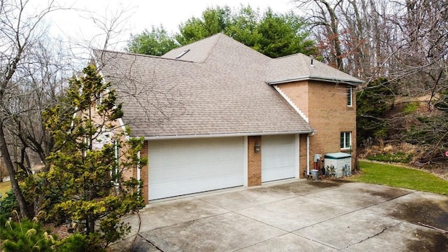 view of side of home with brick siding, a garage, and roof with shingles