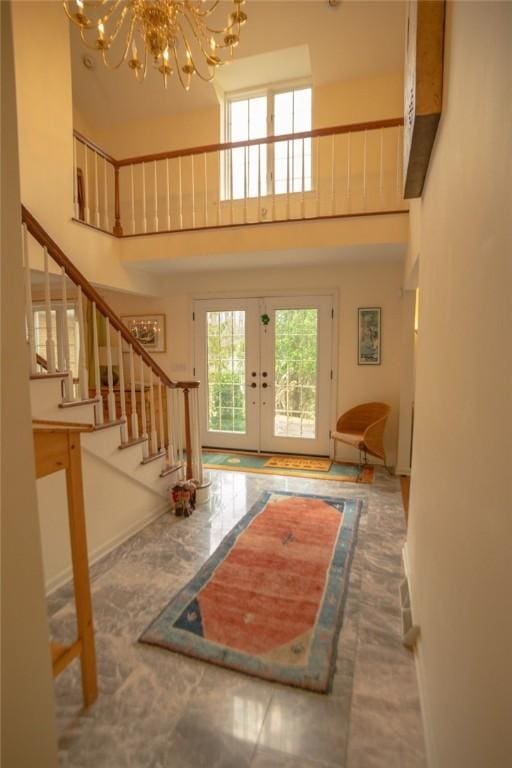 entryway with stairway, baseboards, a high ceiling, french doors, and a chandelier