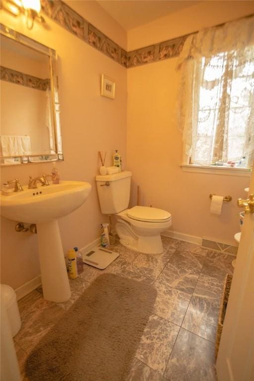 bathroom with baseboards and toilet