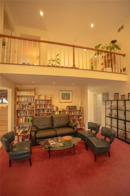 living room featuring carpet flooring, recessed lighting, visible vents, and a towering ceiling