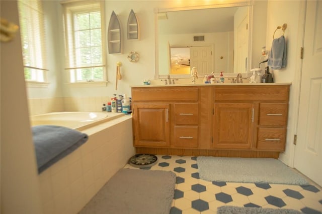 full bath with a sink, visible vents, a garden tub, and double vanity