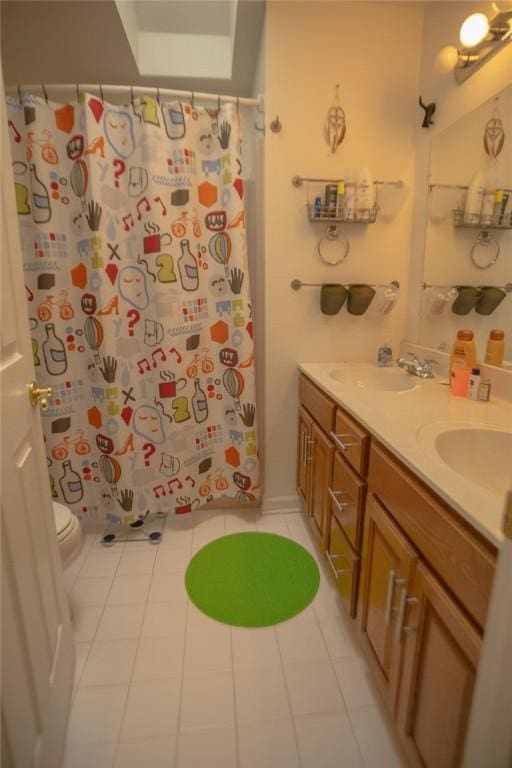 bathroom featuring curtained shower, double vanity, toilet, and a sink