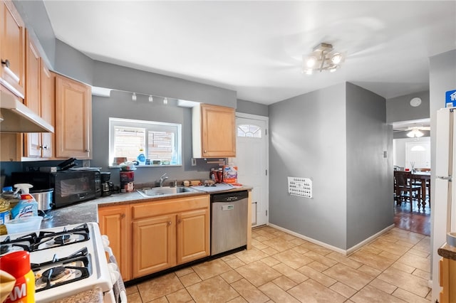 kitchen with light brown cabinetry, white appliances, baseboards, and a sink