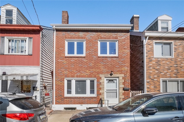 multi unit property with brick siding and a chimney