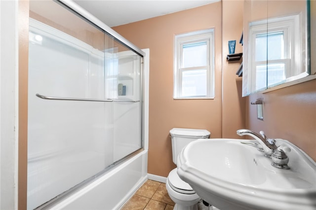 bathroom featuring a sink, plenty of natural light, toilet, and tile patterned flooring