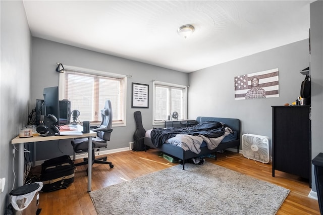 bedroom with wood finished floors and baseboards