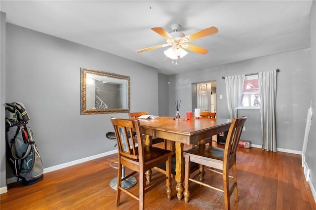 dining area featuring baseboards, wood-type flooring, and ceiling fan