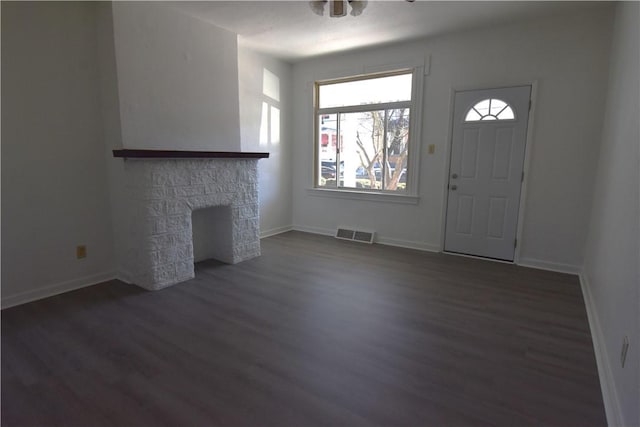 foyer entrance featuring visible vents, baseboards, and dark wood finished floors