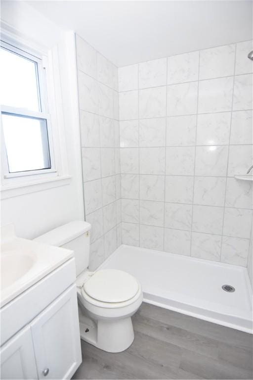 full bathroom with a shower stall, toilet, vanity, and wood finished floors