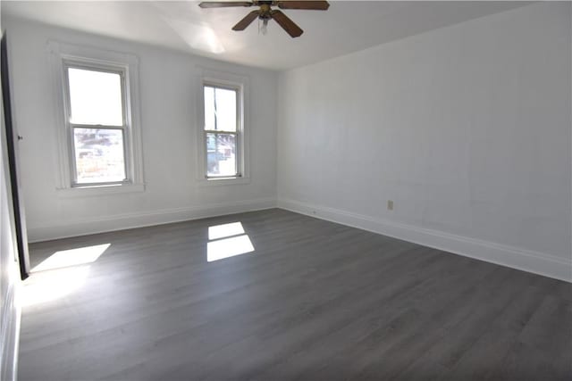 empty room with dark wood finished floors, baseboards, and ceiling fan