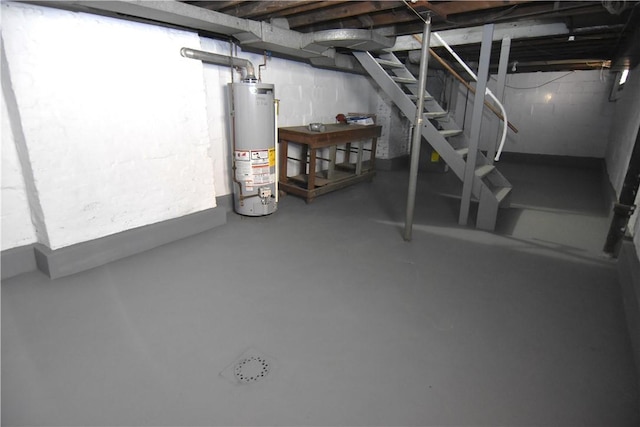 unfinished below grade area featuring stairs and water heater