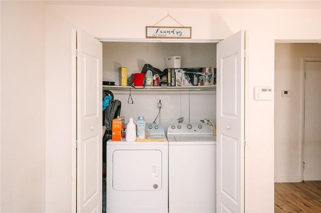 laundry room with laundry area, wood finished floors, and washing machine and dryer