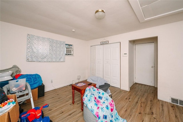 bedroom featuring a closet, visible vents, baseboards, and wood finished floors