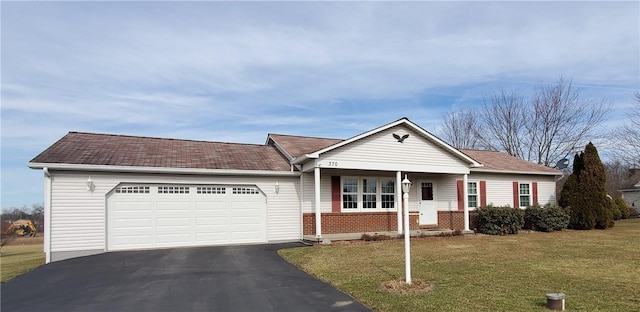 single story home featuring aphalt driveway, brick siding, a garage, and a front yard