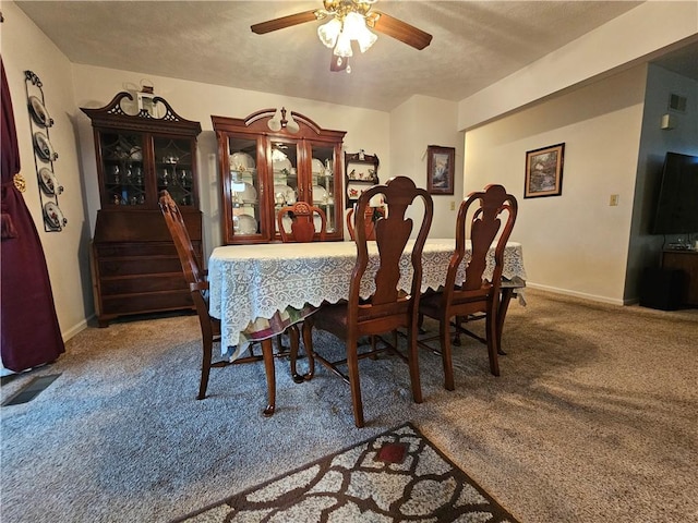 dining room featuring carpet flooring, a ceiling fan, baseboards, and a textured ceiling