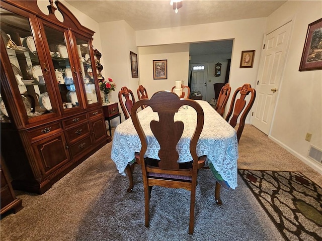 carpeted dining room featuring visible vents and baseboards