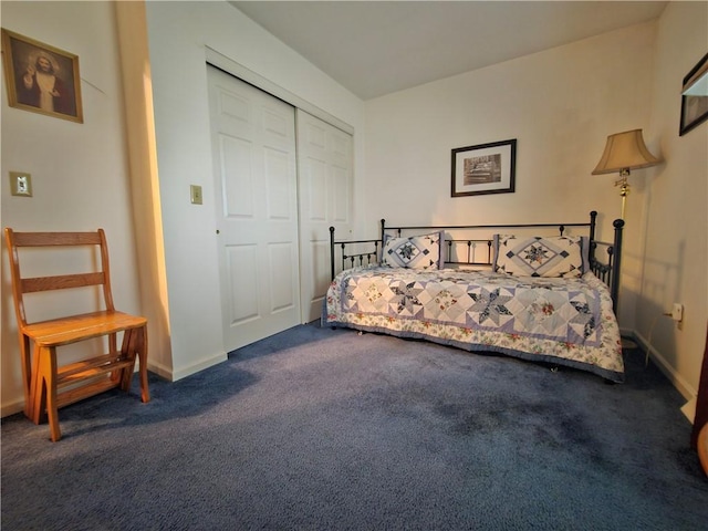 bedroom with a closet, baseboards, and dark carpet