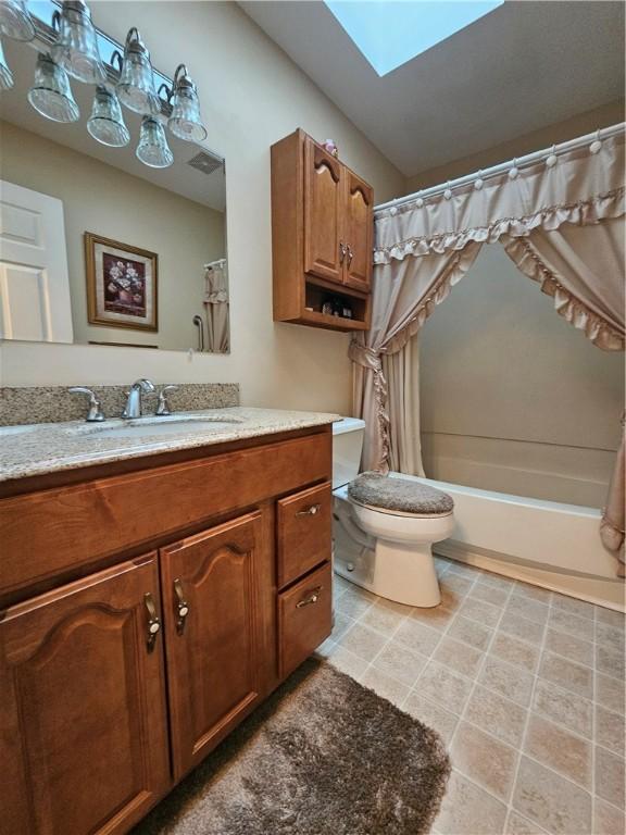 full bath featuring vanity, visible vents, a skylight, shower / tub combo, and toilet