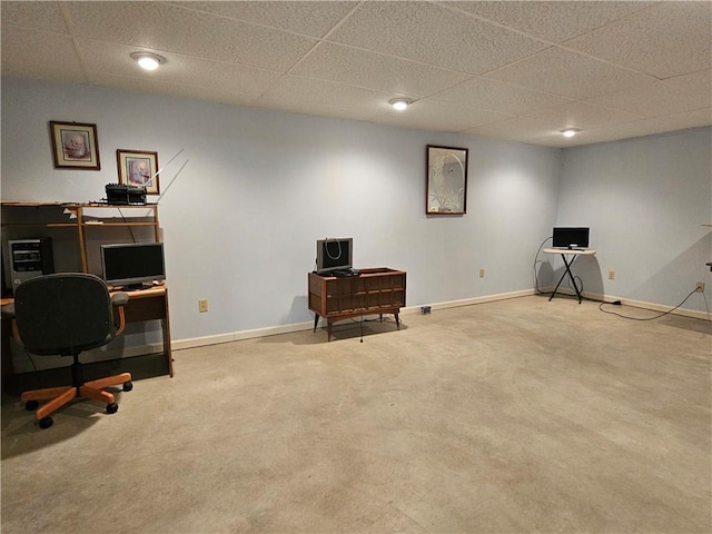 carpeted office space featuring a paneled ceiling and baseboards