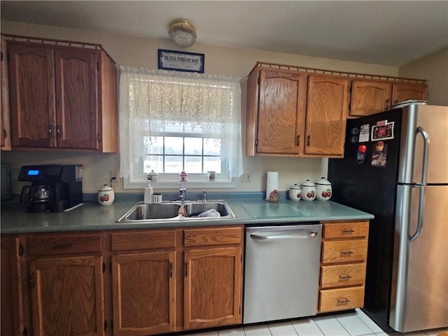 kitchen featuring brown cabinetry, appliances with stainless steel finishes, and a sink