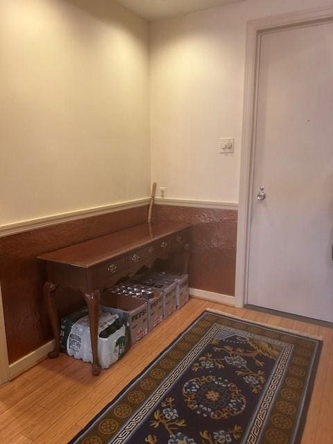 bathroom with wood finished floors and wainscoting