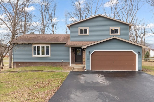 split level home with aphalt driveway, a front lawn, and roof with shingles